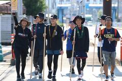 2025年の武者修行：杖を手に、街なかを並んで歩く参加者たち