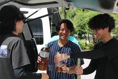 2026年の武者修行：車のそばで飲み物を囲み、談笑する仲間たち